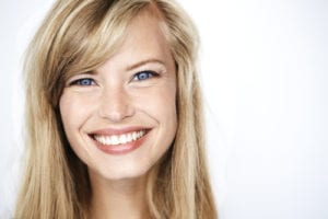 Bright eyed blond woman smiling to camera, portrait