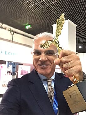 Dr. Calabria holding up an award statuette